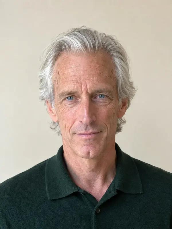 A man in his sixties with longer silver hair swept back