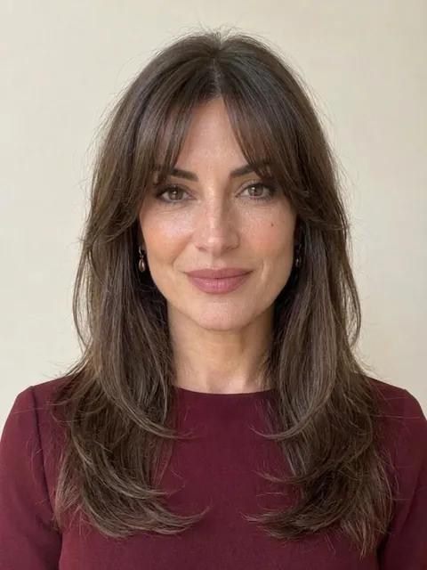 A woman in her forties with a shoulder-length hush cut and soft wisps