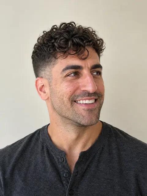 The same man with his head turned to the side, looking away from the camera