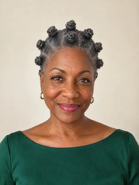 A Black woman in her fifties with silver bantu knots