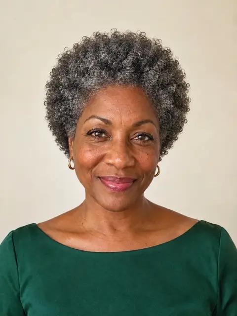 A Black woman in her fifties with a round silver curly afro