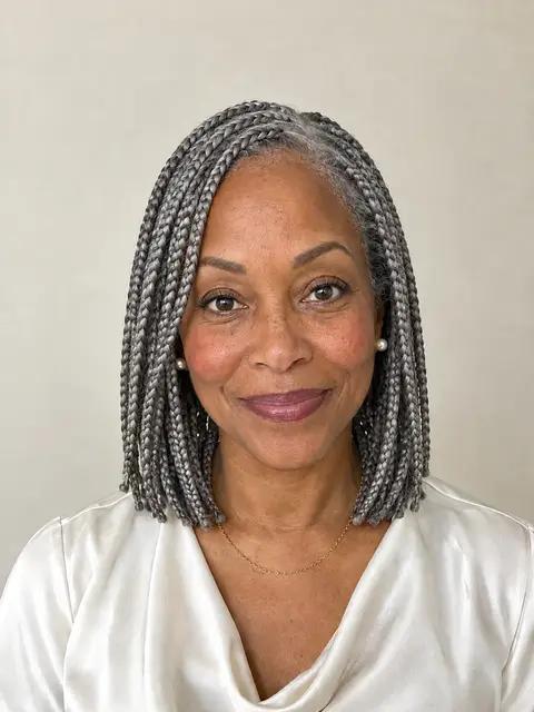 A Black woman in her sixties with shoulder-length knotless box braids