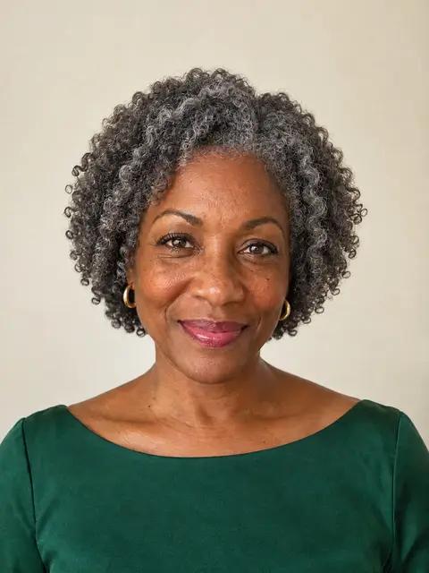 A Black woman in her fifties with a chin-length silver twist-out