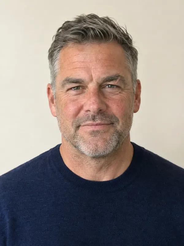 A man in his fifties with an oval face and short salt-and-pepper hair